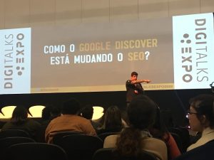 imagem de Felipe Bazon palestrando n palco do Digitalks Expo, com o slide sobre 'como o google discover está mudando o SEO?'